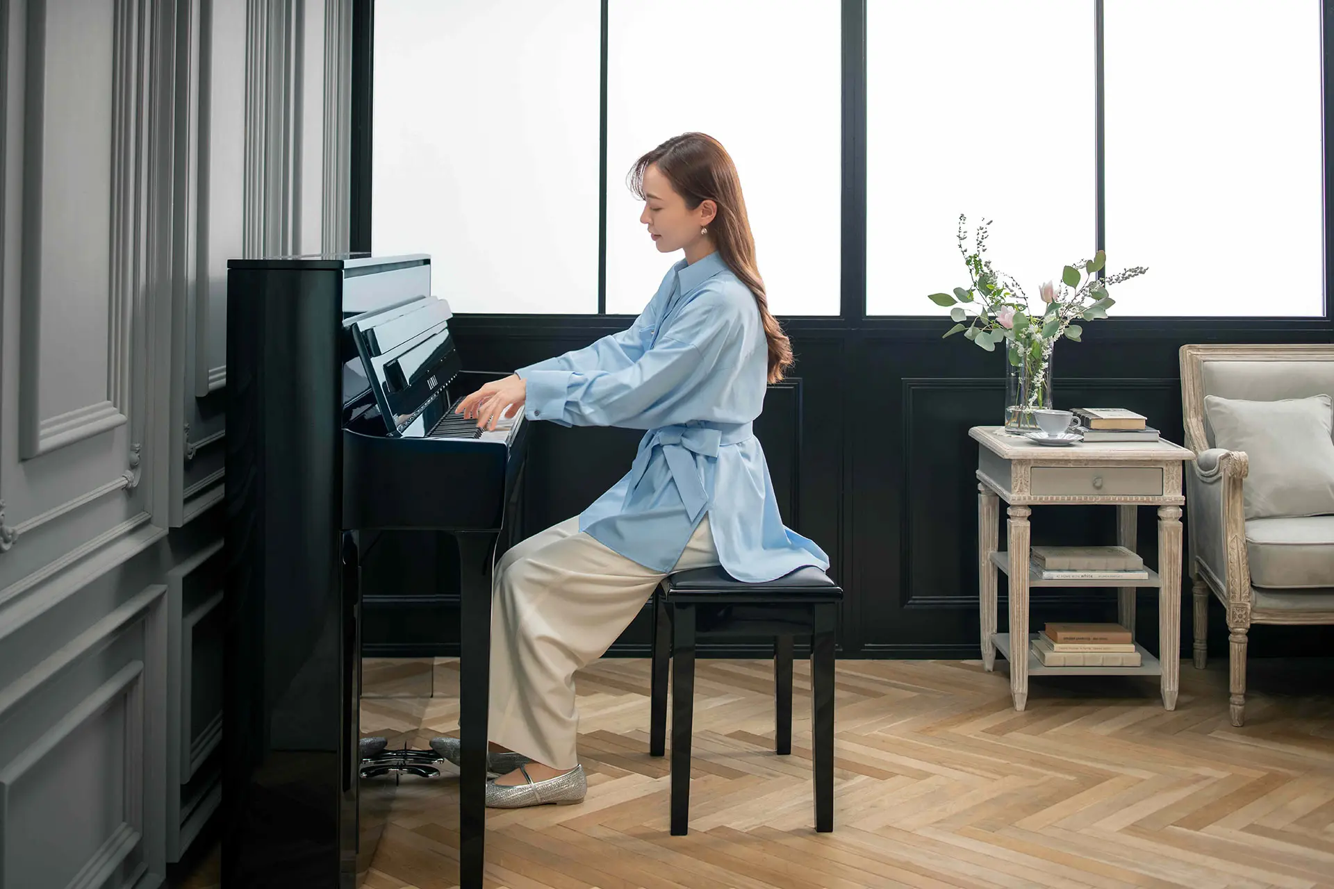 Frau spielt seitlich gesehen an einem Kawai NOVUS Hybridpiano